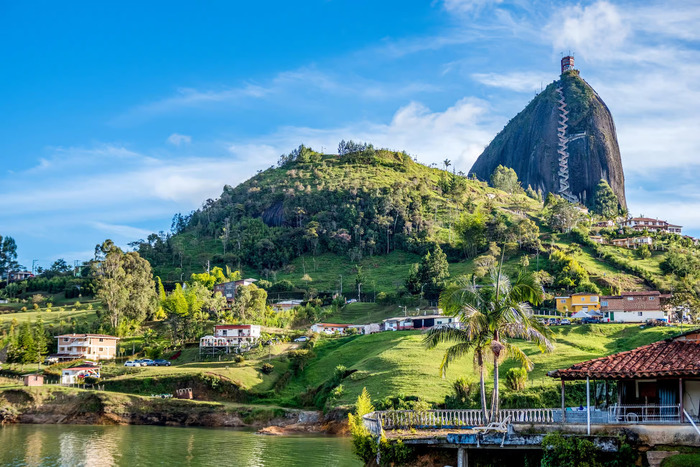 A scenic lakeside view of the majestic Guatapé Rock, demonstrating the beautiful landscapes on this popular day trip from Medellin.