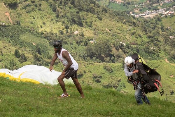 A close-up of a happy participant enjoying the adrenaline and scenery on a paragliding day trip from Medellin.