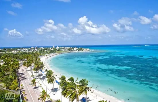 A long, white-sand beach with palm trees and calm turquoise waters on San Andrés, one of the most popular Colombian islands.