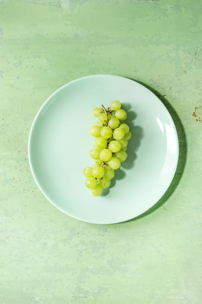 Bunch of green grapes A plate of green grapes, representing one of the most famous Colombian New Year traditions: eating twelve grapes at midnight for good luck in the coming year.