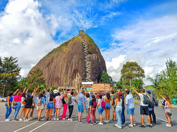 group of people infront of the guatape rock el penol visiting and enjoying the best day trip from medellin