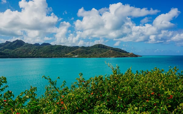 Panoramic view from a high point over a turquoise bay and lush green hills on Santa Catalina island, one of the most beautiful Colombian islands.