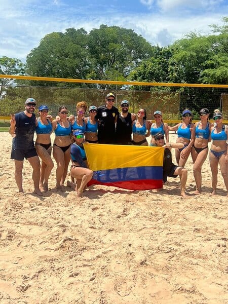 Beach volleyball team in Medellin proudly holding the Colombian flag, celebrating the community spirit of medellin volleyball and local sport life medellin.