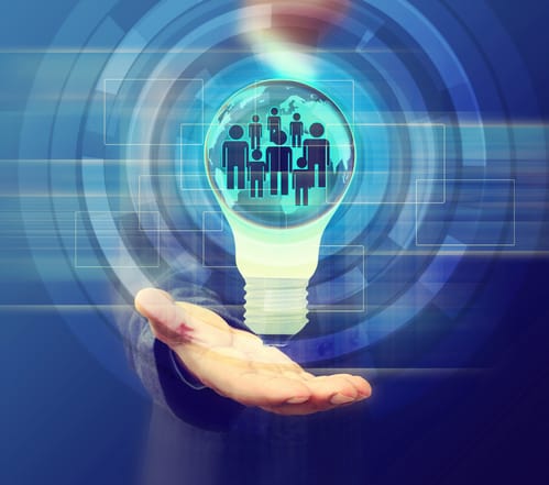 Hand presenting a glowing light bulb with a digital community graphic, representing blockchain innovation and the crypto Medellin tech hub.