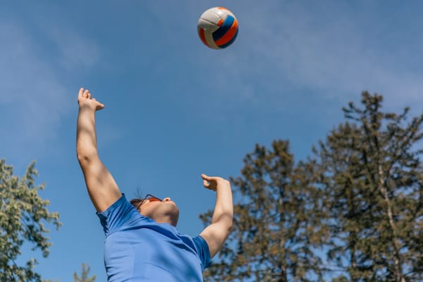 Player serving under a blue sky, a dynamic example of medellin volleyball and the passion for sport life medellin.