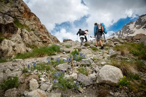 a-group-of-friends-climbed-high-in-the-mountains-2024-12-05-04-34-26-utc-2-min Andean trekking season in Colombia: hikers climbing a rocky mountain path under dramatic clouds, cooler temperatures in Colombia at higher altitude.