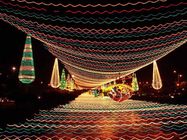CHRISTMAS-Alumbrados_del_Rio-2007-Medellin Colorful holiday light canopy over a street in Colombia at night, highlighting christmas traditions colombia and December festivities.